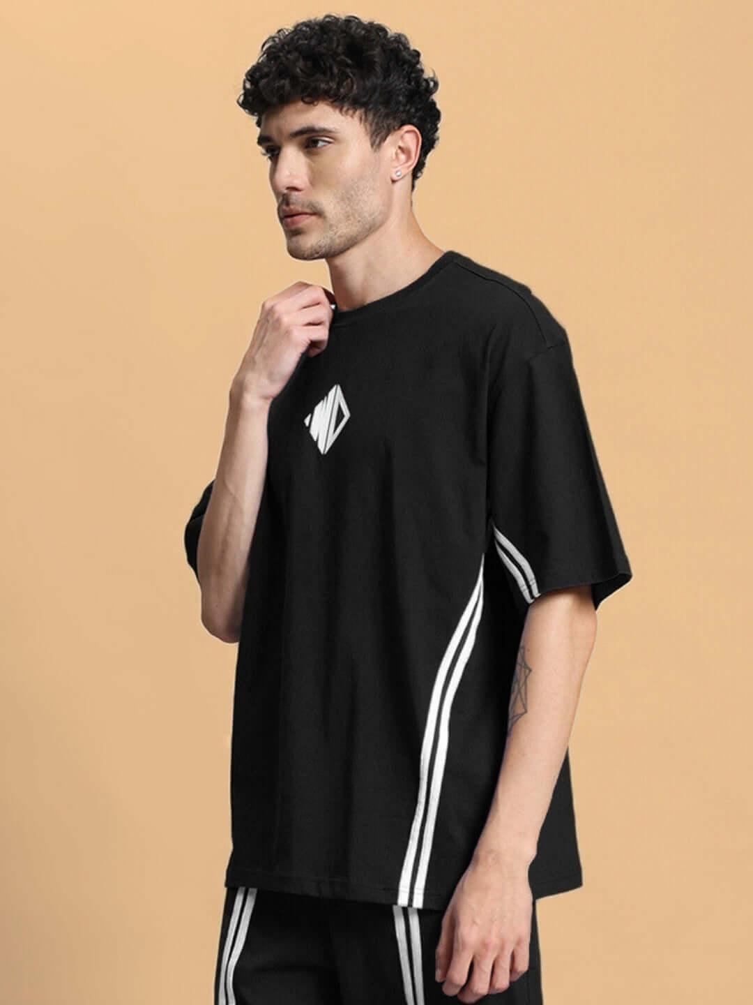 Man wearing OUTLOOK OVER-SIZED T-SHIRT BLACK with minimalist design, showcasing relaxed fit and versatility for streetwear style.