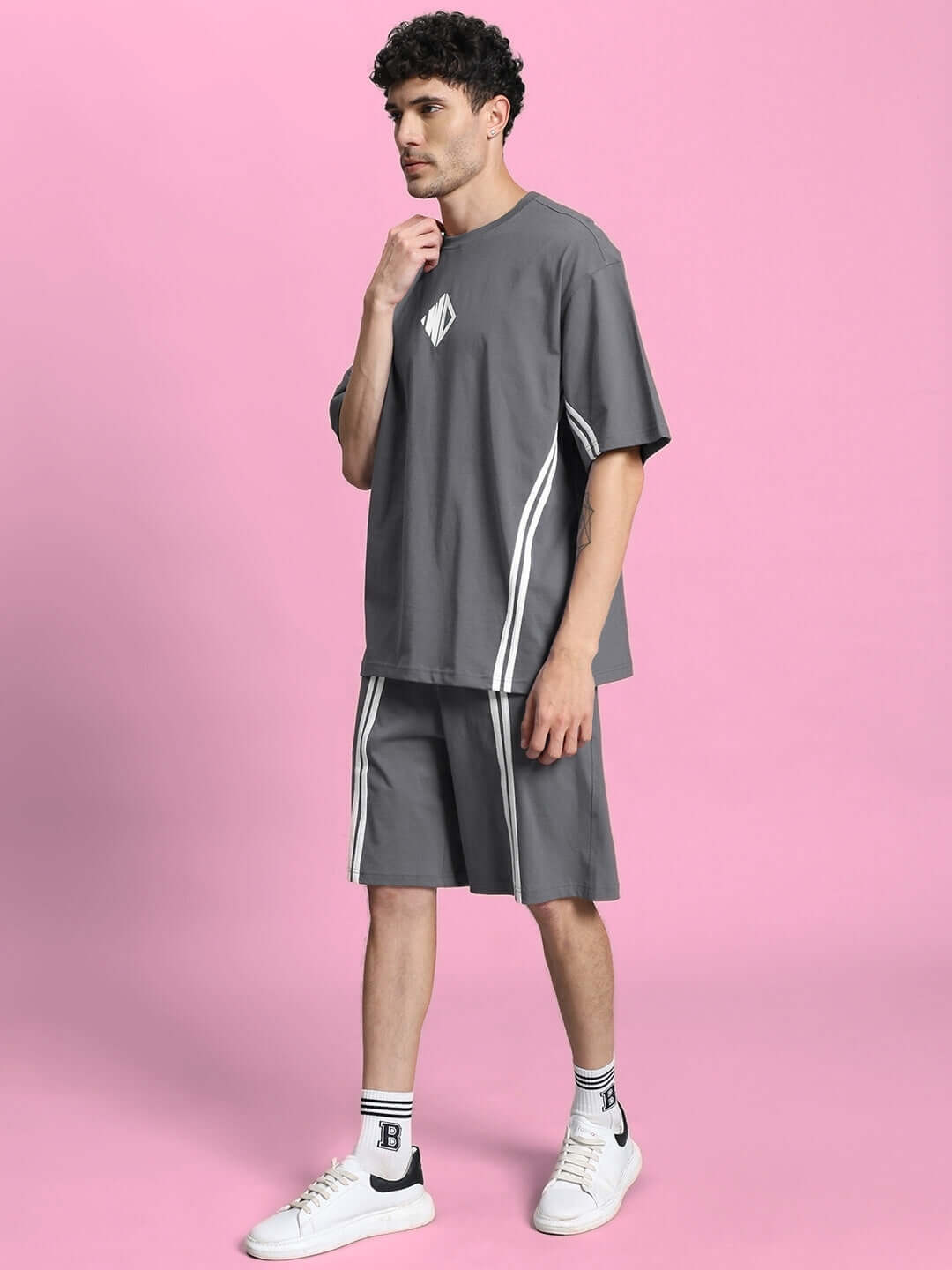 Model wearing OUTLOOK SUMMER CO-ORD SHORTS SET GREY with a relaxed fit, standing against a pink background.