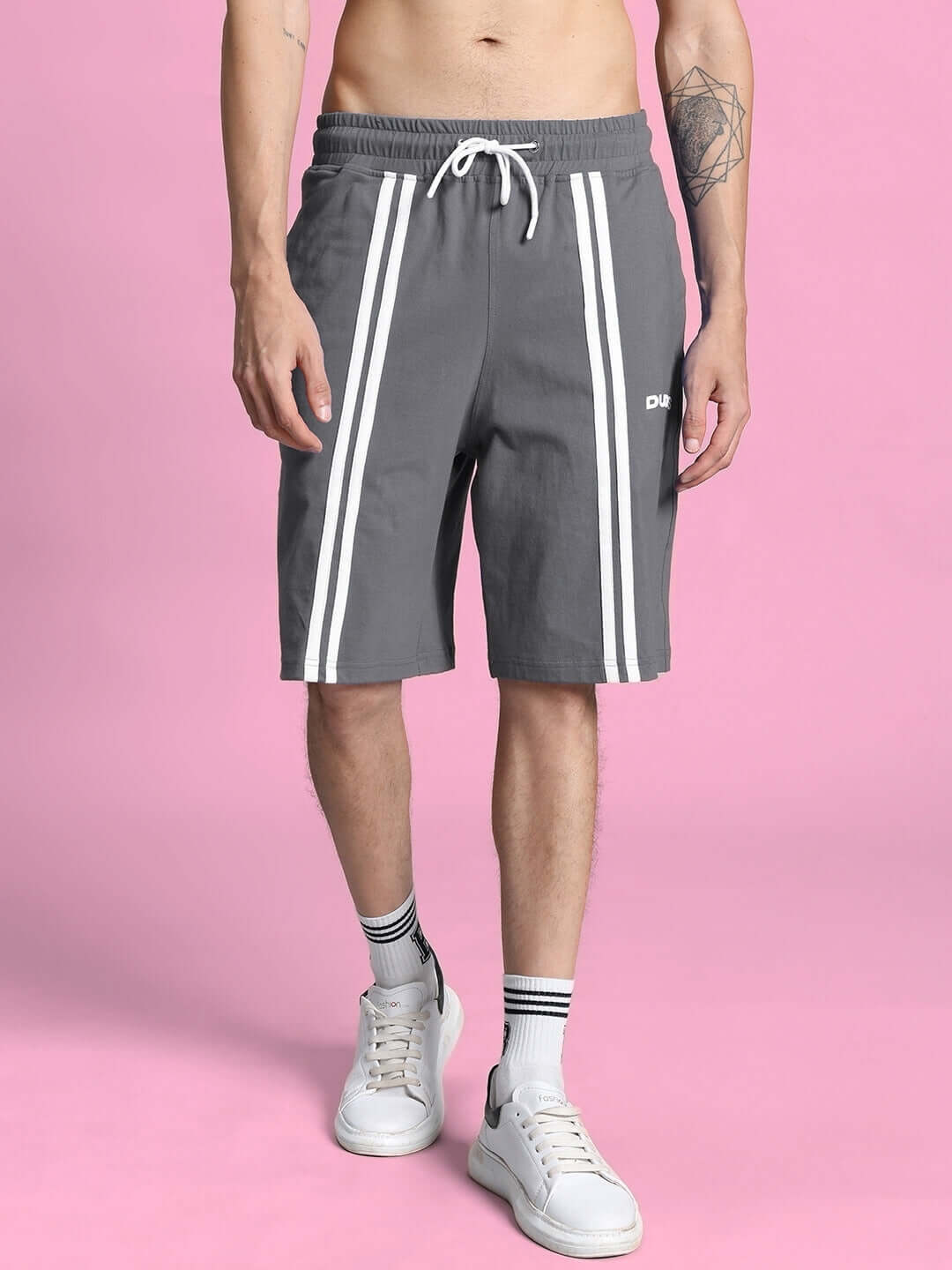 Man wearing OUTLOOK SUMMER CO-ORD SHORTS SET GREY standing against pink background
