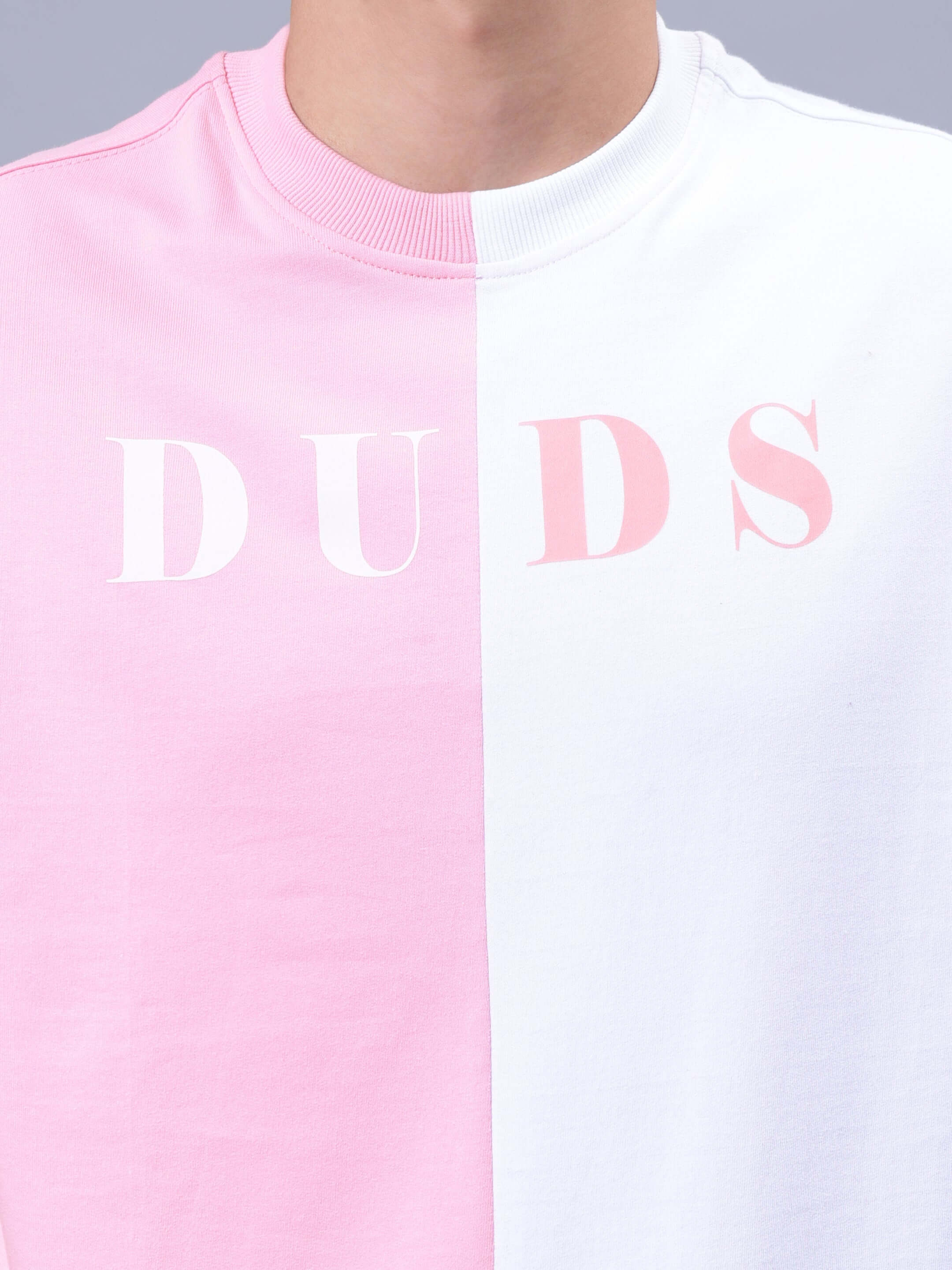 G.O.A.T oversized T-shirt in pink and white with "DUDS" text, made of premium cotton French terry for comfortable wear.