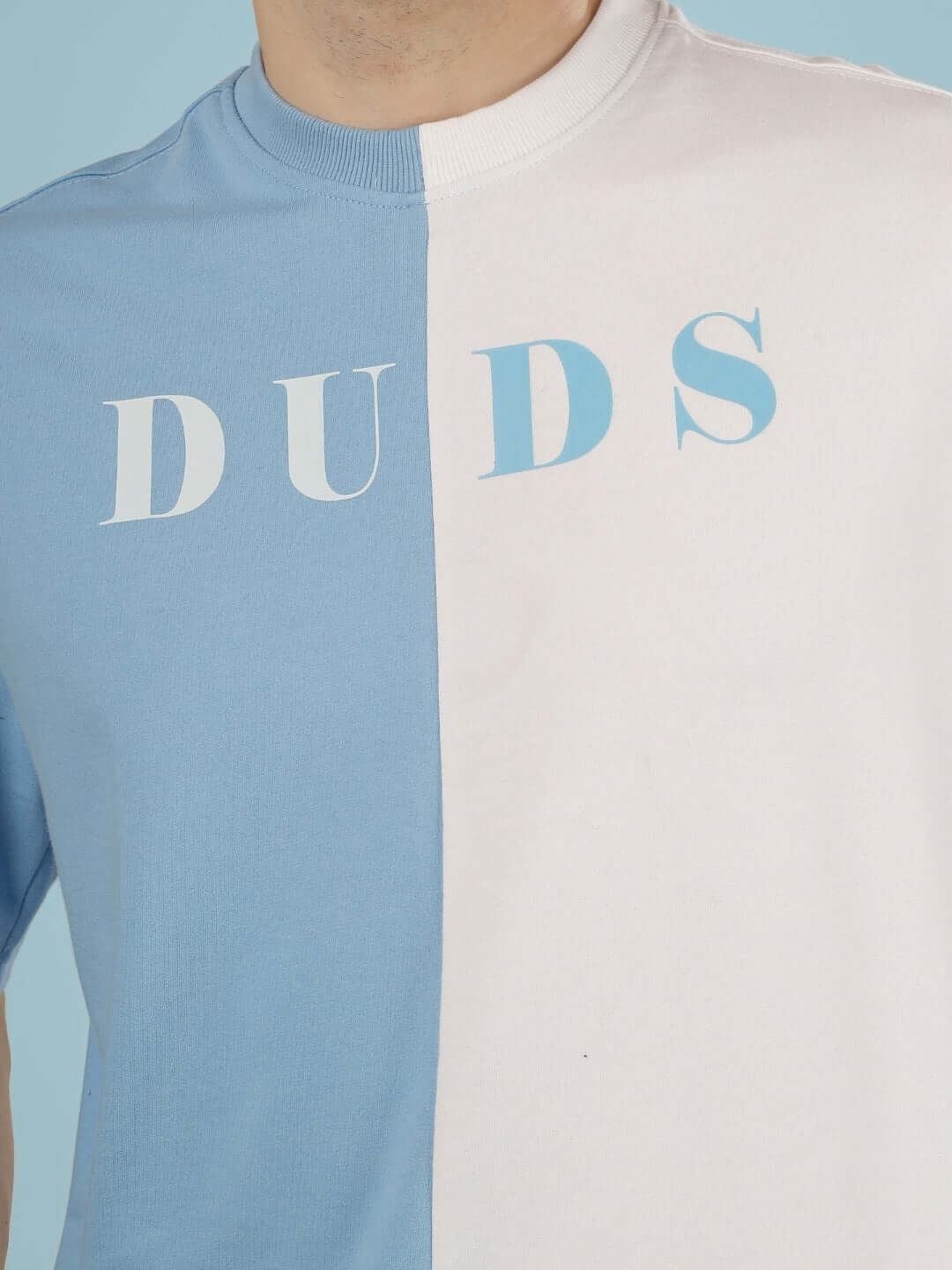 G.O.A.T oversized t-shirt in sky blue and white with a bold 'DUDS' print, made from premium cotton French terry for stylish comfort.