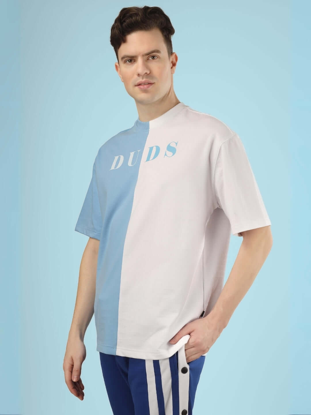 Man wearing G.O.A.T oversized sky blue and white t-shirt made of premium heavy gauge fabric, suitable for cold machine wash; fashion apparel.