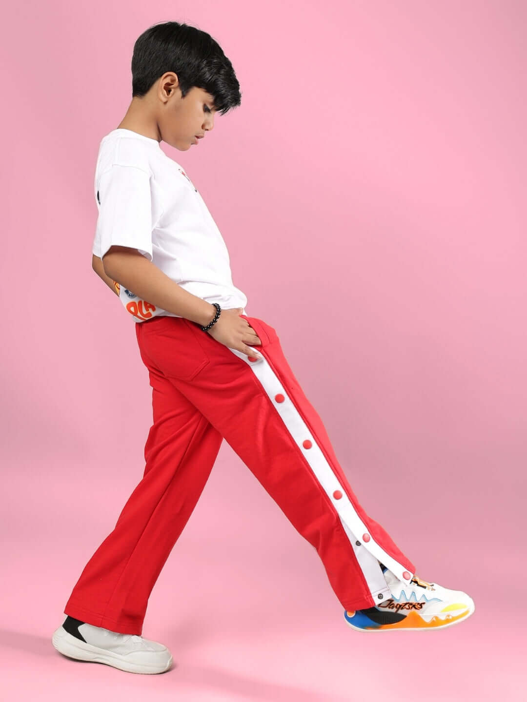 Child wearing Paloma T-Shirt for Boys Girls White with red pants against a pink background, showcasing style and comfort.