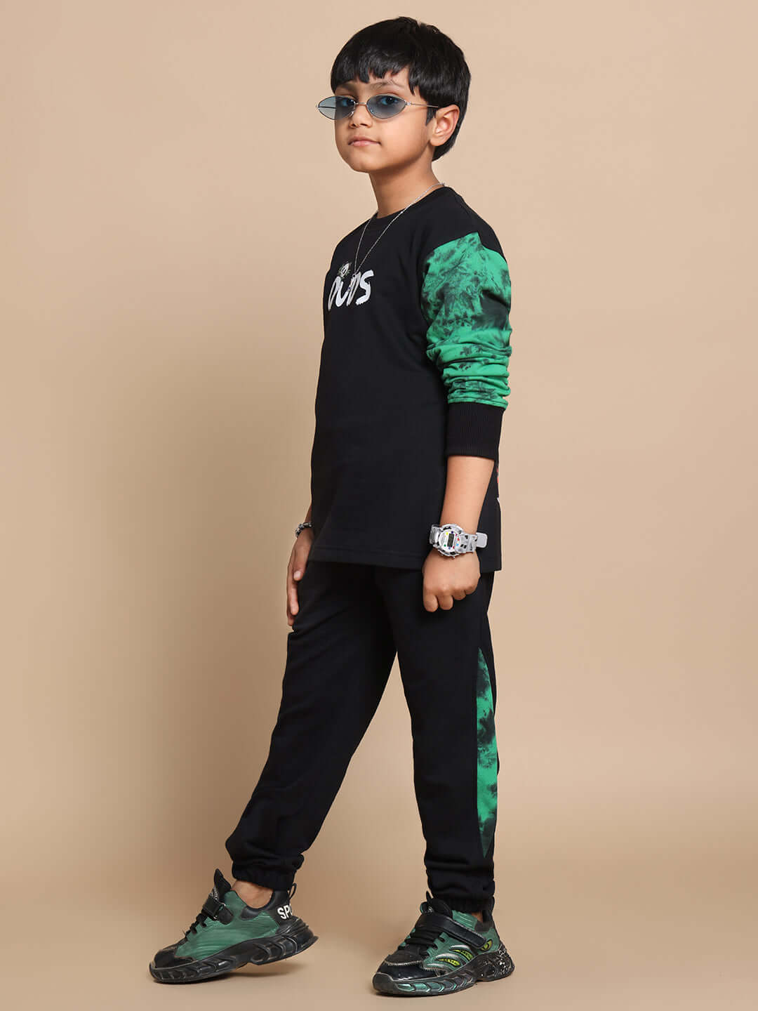 Child wearing black panda co-ord set with green accents, featuring text "DUDS" on the top.