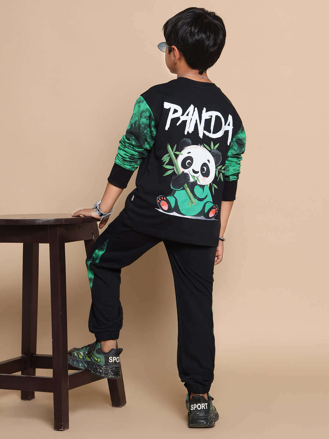 Boy wearing a black panda-themed co-ord set, featuring green accents and panda graphics, from DUDS, tailored for boys and girls.
