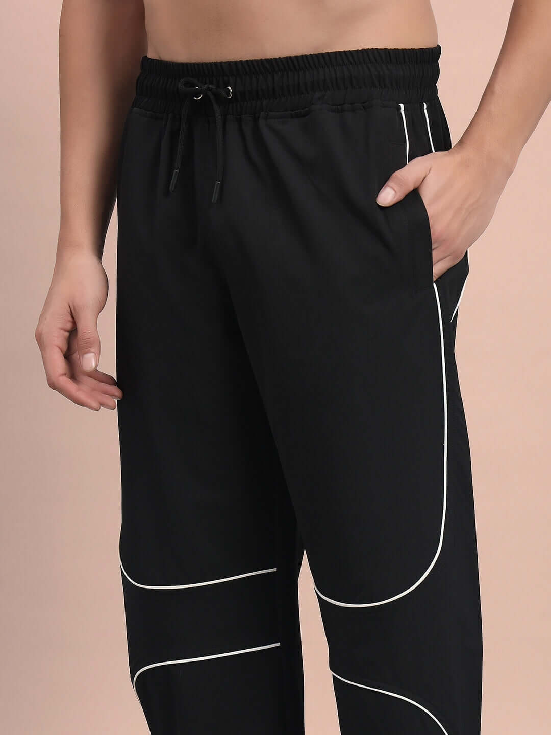 Model wearing black parabolic parachute cargo pants with drawstring and white piping details, available for custom fit.