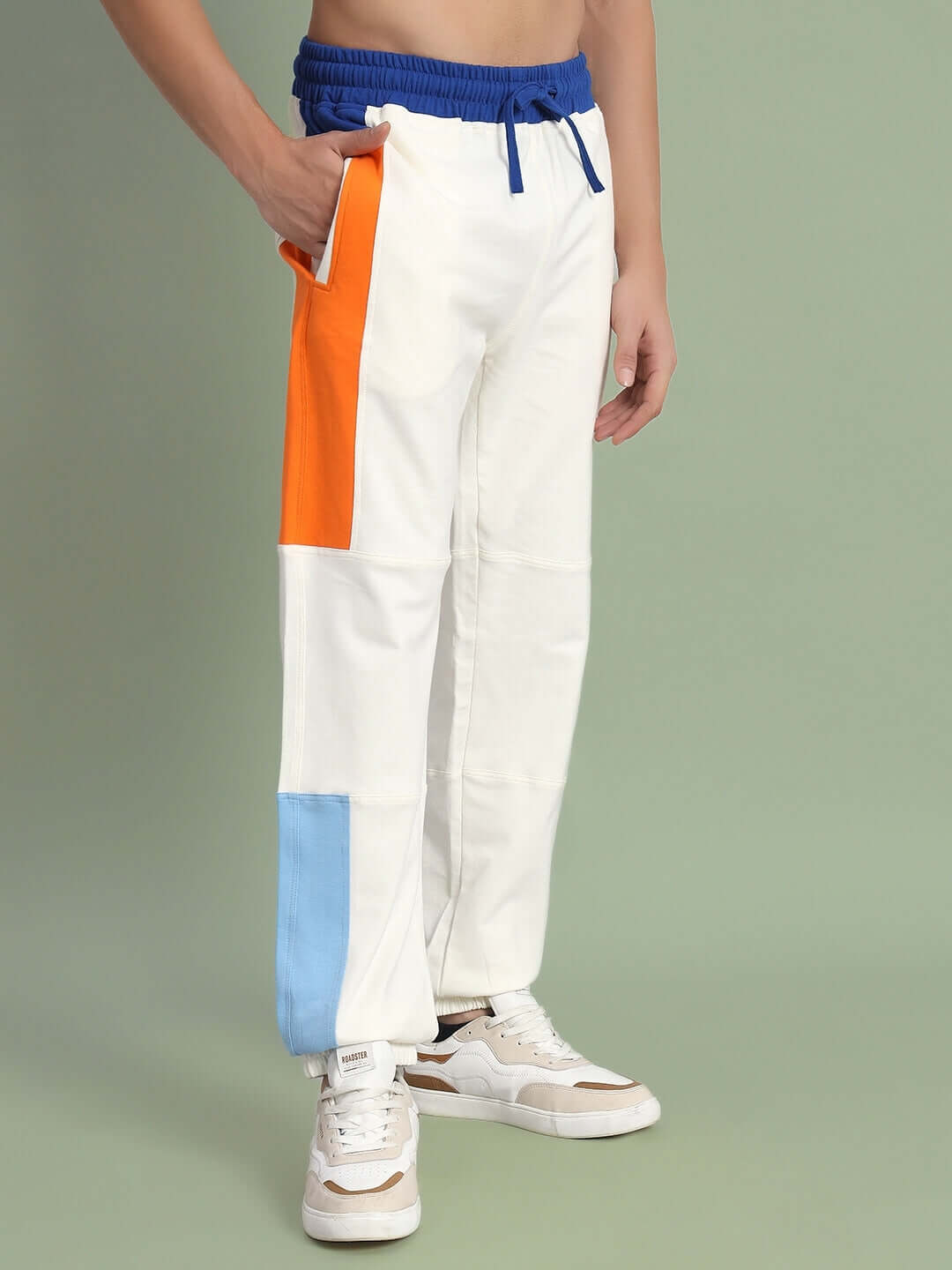 Off-white joggers with blue and orange side contrast, featuring a drawstring waist, made to order for DUDS.