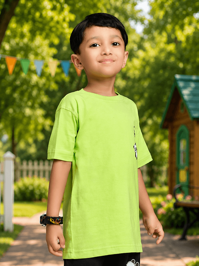 A child wearing a PEEK-A-PANDA T-SHIRT FOR BOYS GIRLS LIME GREEN, smiling in a vibrant outdoor setting.