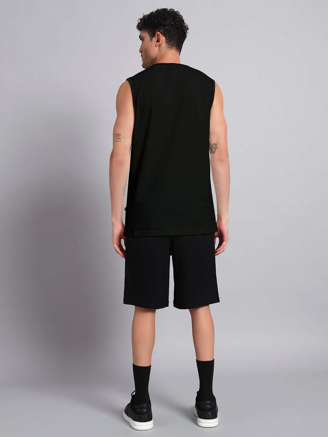 Back view of model wearing PEONIES SKULL CO-ORD SET BLACK showcasing edgy streetwear design.