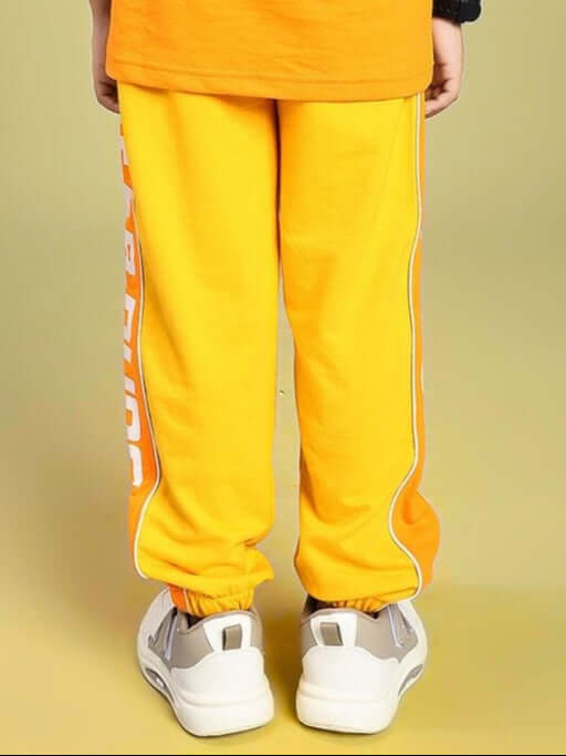Child wearing PEPPY JOGGER FOR BOYS AND GIRLS ORANGE with relaxed fit and vibrant color, suitable for play and adventure.