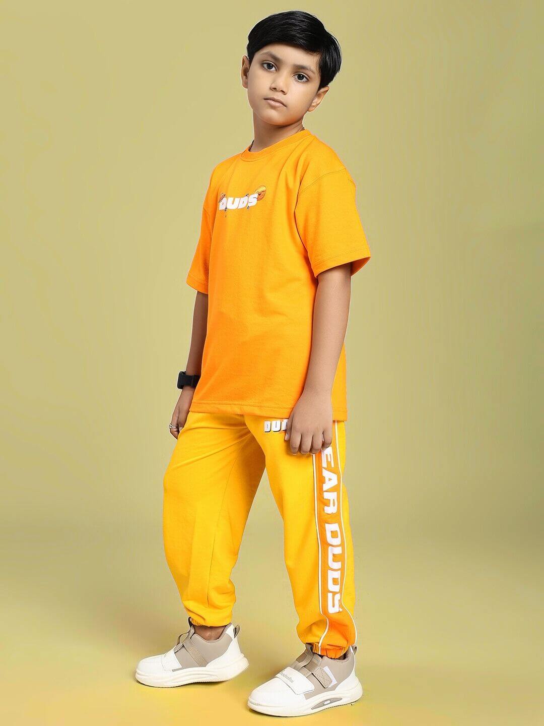 Child wearing PEPPY JOGGER FOR BOYS AND GIRLS ORANGE outfit, showcasing vibrant orange joggers with a relaxed fit and breathable fabric.