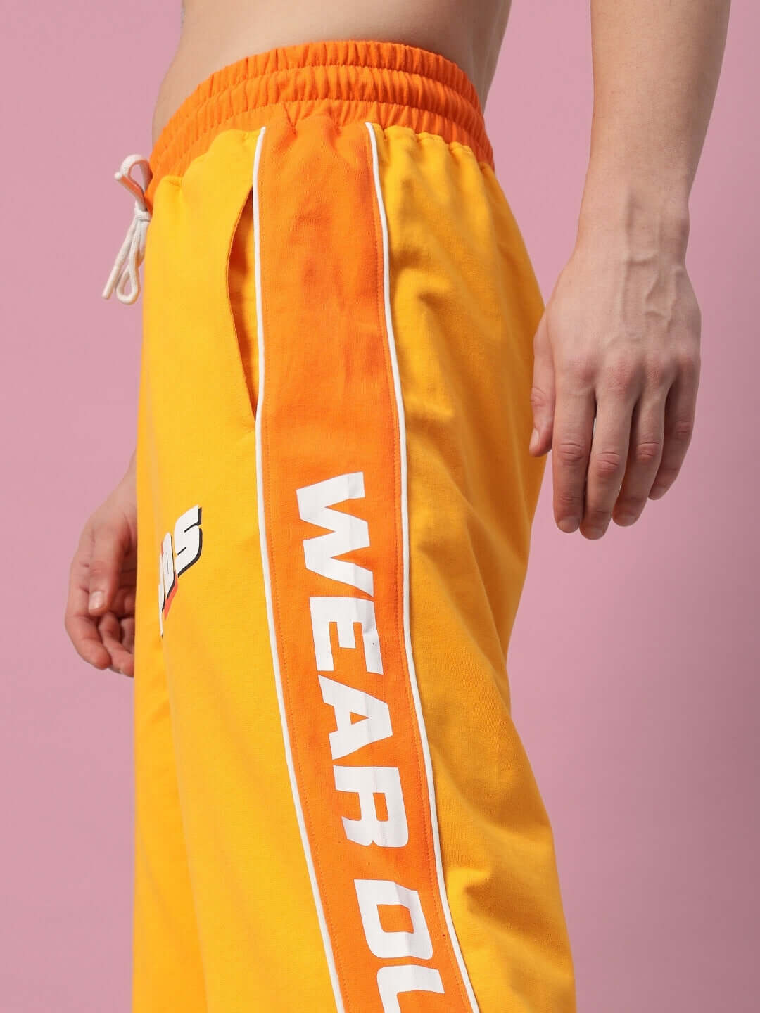 Man wearing Peppy Joggers in yellow-orange, custom fit available, side view showing slogan and comfortable waistband.