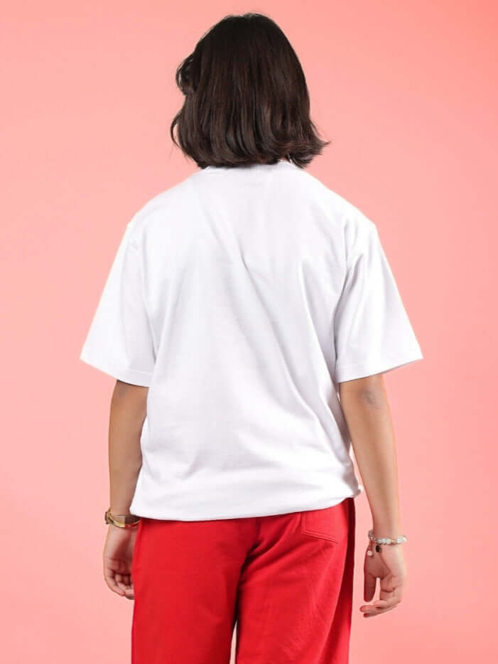 Child wearing PETER T-SHIRT FOR BOYS GIRLS WHITE, showcasing simple and comfortable design, paired with red pants, back view.