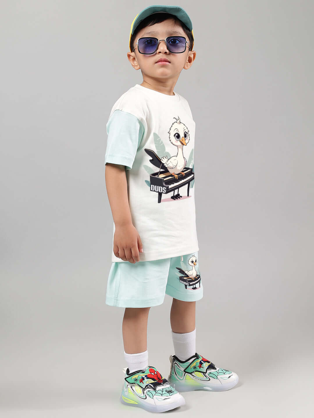 Child wearing Piano Bird Co-Ord set for boys and girls in off white and blue, featuring comfortable shorts and top with bird design.