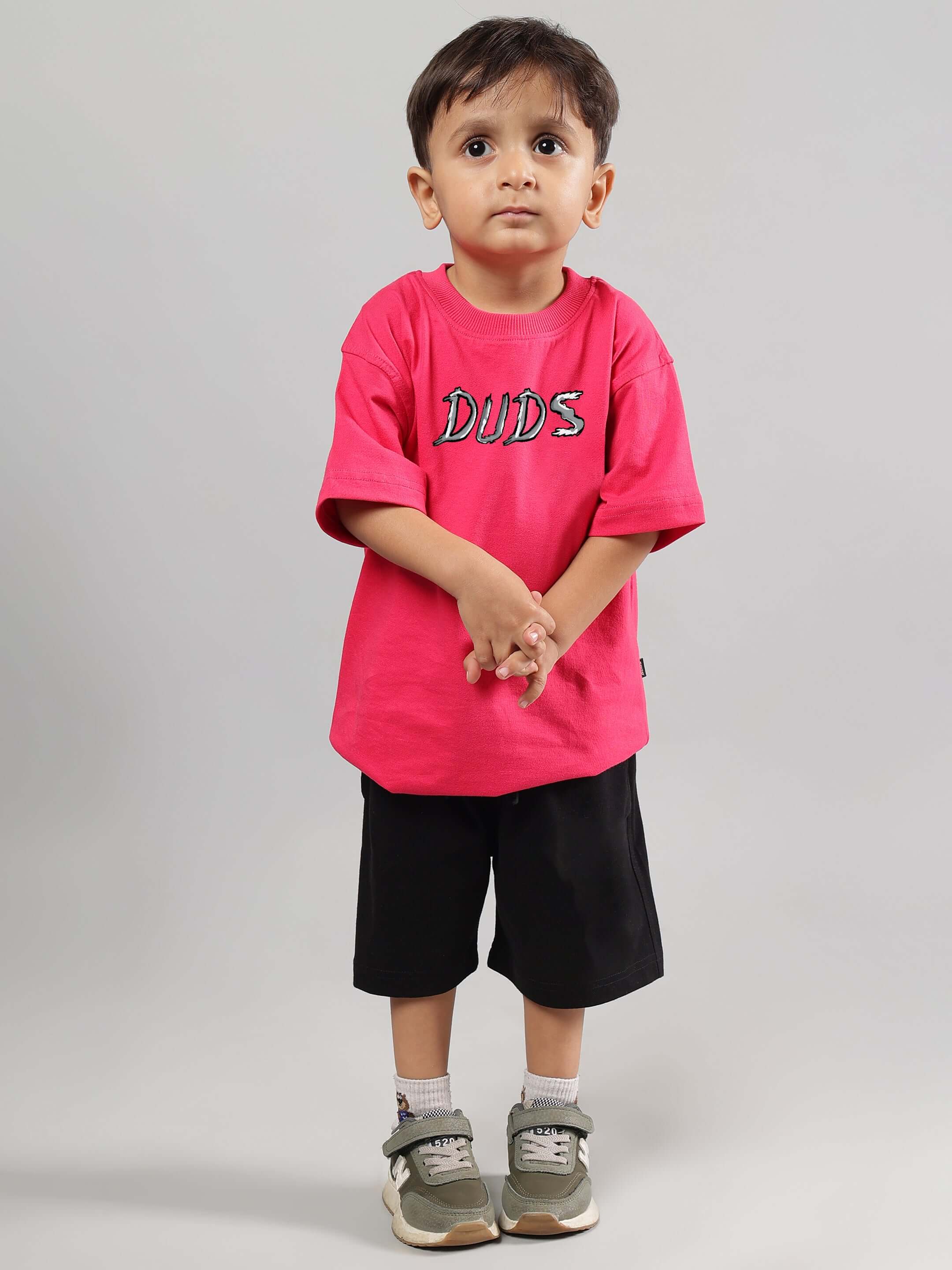 Young child wearing pink "DUDS" T-shirt, positive rabbit design, paired with black shorts and sneakers, perfect for boys & girls.