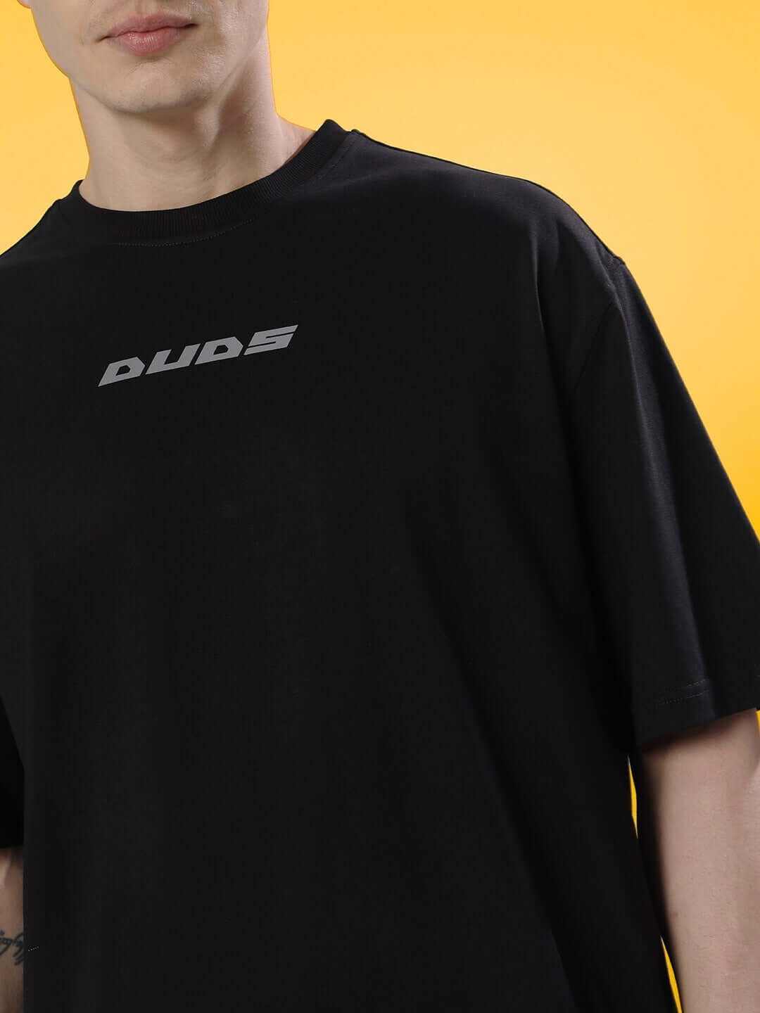 Black oversized t-shirt with Poison Skull design, 97% premium cotton, shown against a yellow background.