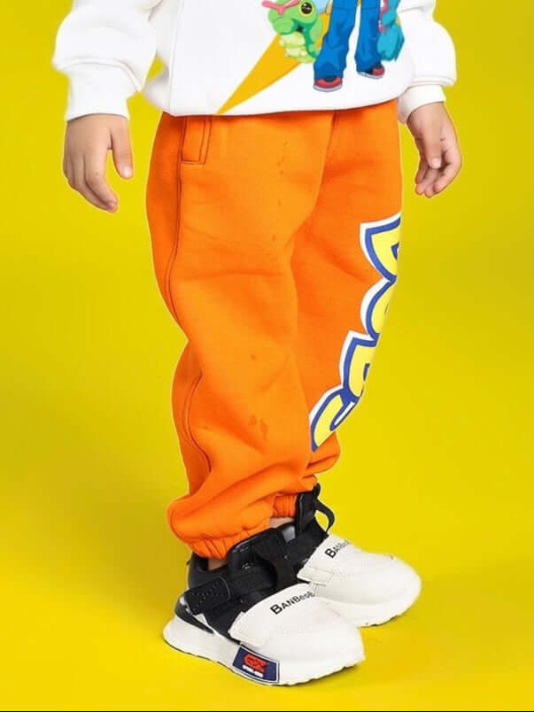 Child wearing POKEMON TOON FLEECE JOGGER FOR BOYS AND GIRLS ORANGE, featuring cartoon design on vibrant orange background.