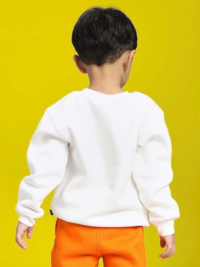 Boy wearing POKEMON TOON FLEECE SWEATSHIRT FOR BOYS AND GIRLS OFF-WHITE with orange pants on a yellow background.