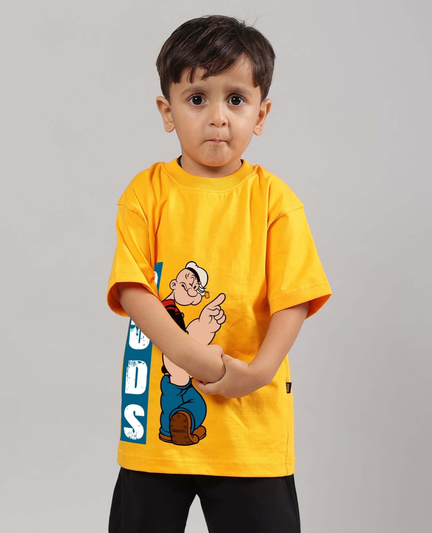 Child wearing yellow Popeye t-shirt for boys and girls, featuring DUDS customization options.