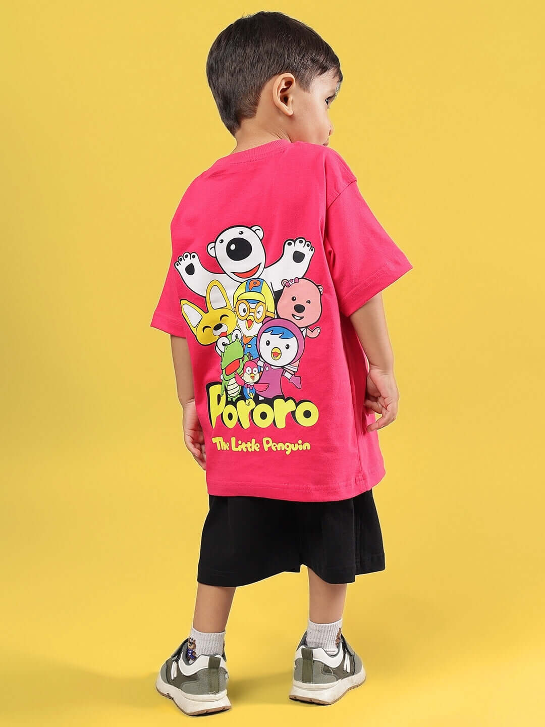 Boy wearing PORORO CO-ORD FOR BOYS & GIRLS PINK-BLACK set with cartoon design on back, yellow background