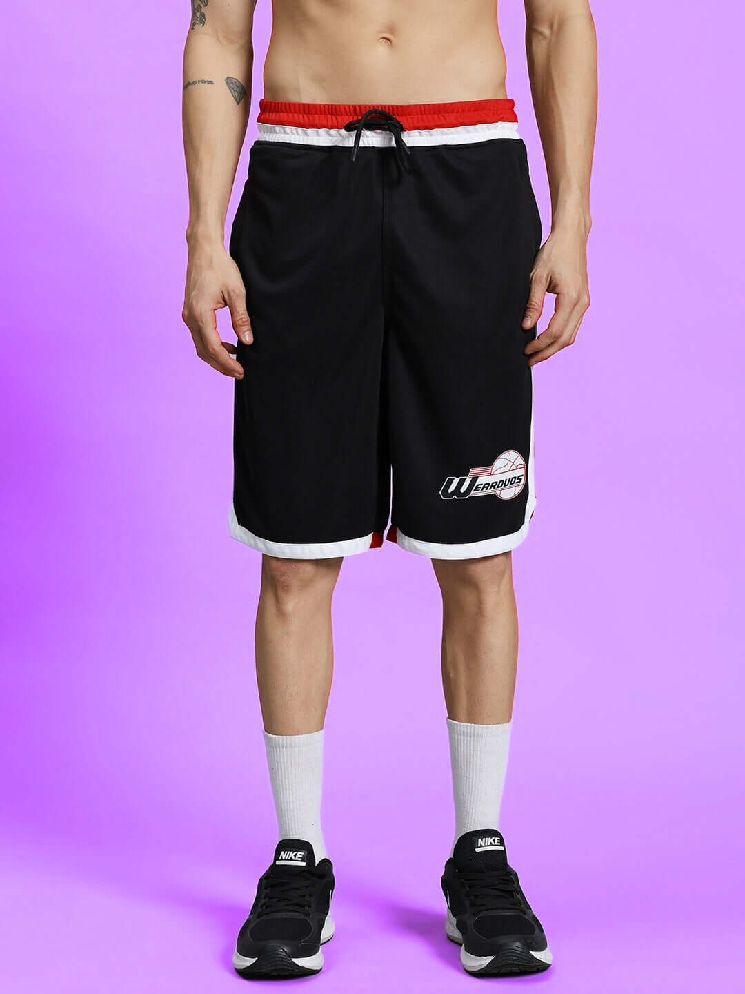 PORTIA REGULAR FIT SHORTS BLACK worn by a model on a purple background, showcasing sporty design and comfortable fit.