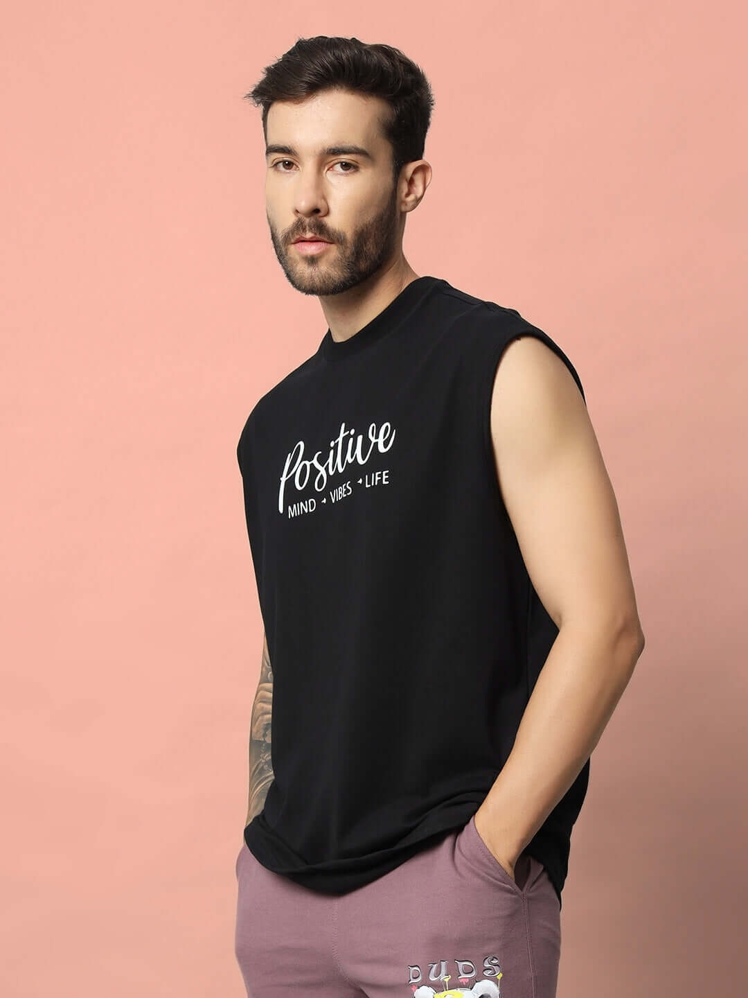 Man wearing a black Positive Life Gym T-shirt by DUDS, showcasing 'Mind, Vibes, Life' text, available with custom fit option.