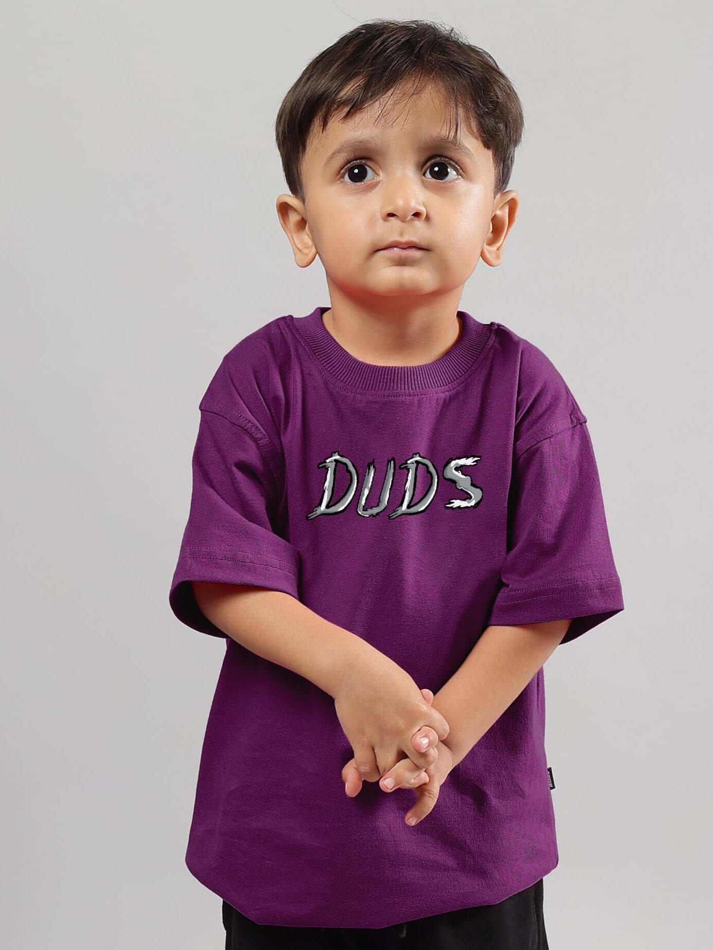 Young child wearing a purple 'DUDS' t-shirt, showcasing a positive rabbit design suitable for boys and girls.