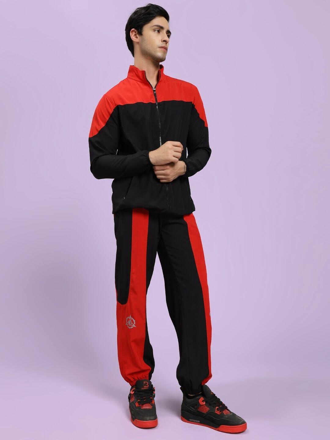 POWER BLOCK CO-ORD SET BLACK RED Person wearing a black and red tracksuit on a light purple background