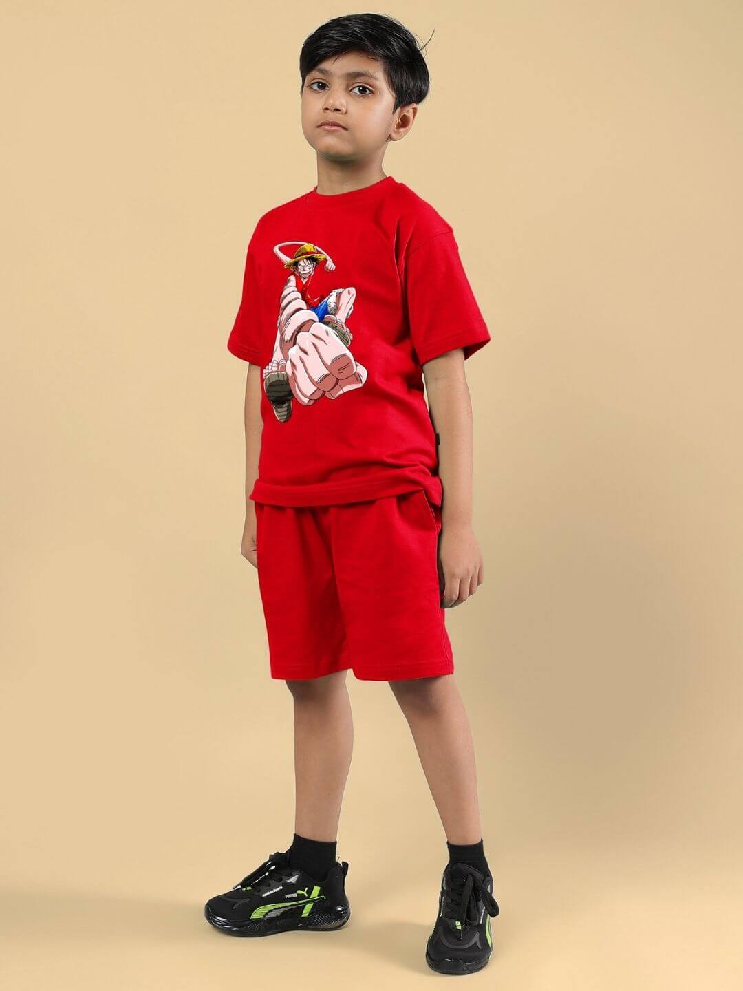 Child wearing Power Punch Co-ord Set in red, featuring a bold design for boys and girls, includes T-shirt and shorts.