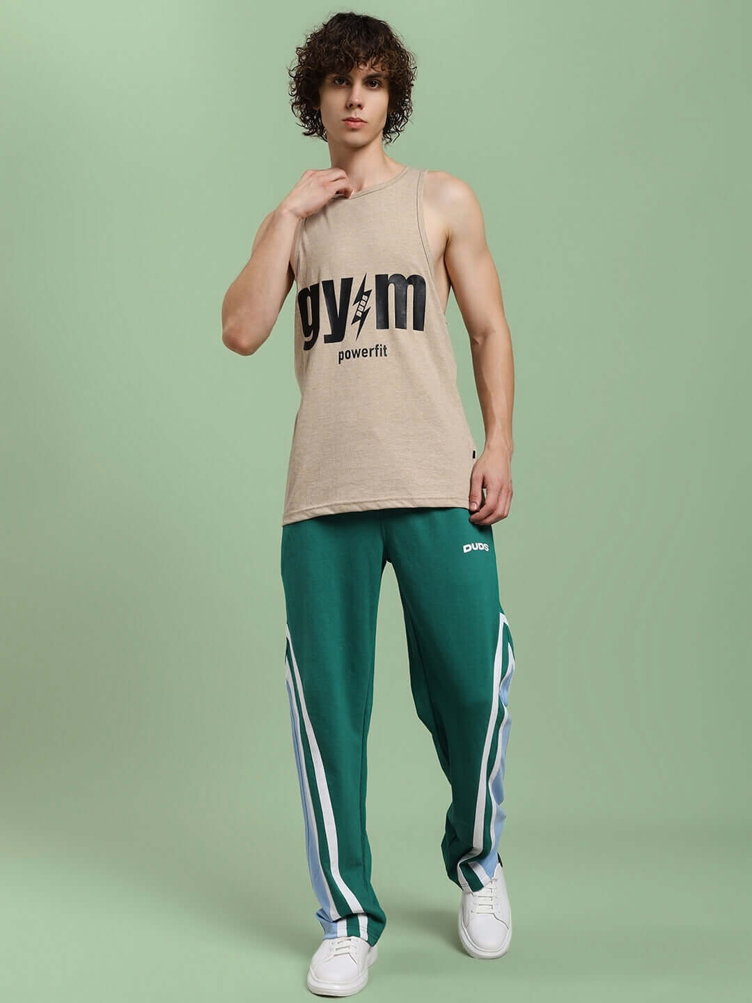 Model wearing beige Powerfit Fitness Gym T-shirt with green track pants, ideal for customizable fit options.