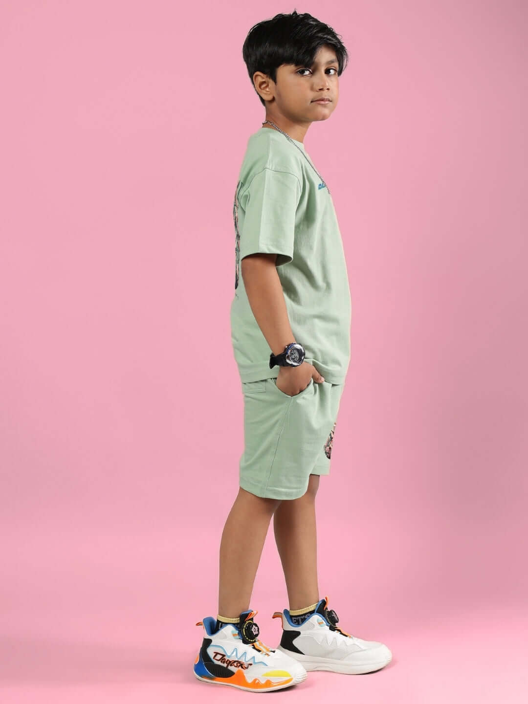 Boy wearing PRAY & PEACE CO-ORD FOR BOYS & GIRLS NYANZA GREEN on pink background