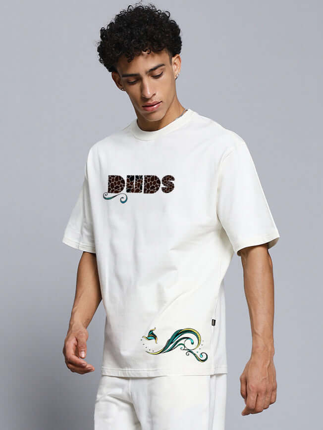 Model wearing premium off-white oversized t-shirt with fish print, made from heavy gauge cotton fabric, showcasing casual style.
