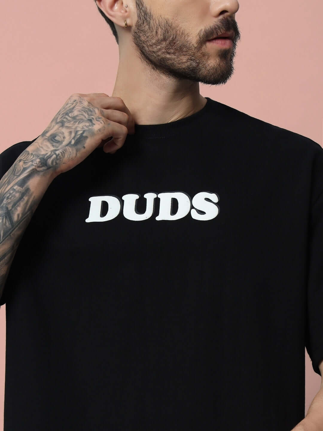 Model wearing black DUDS oversized t-shirt with puff print, made from premium cotton blend fabric, perfect for casual wear.