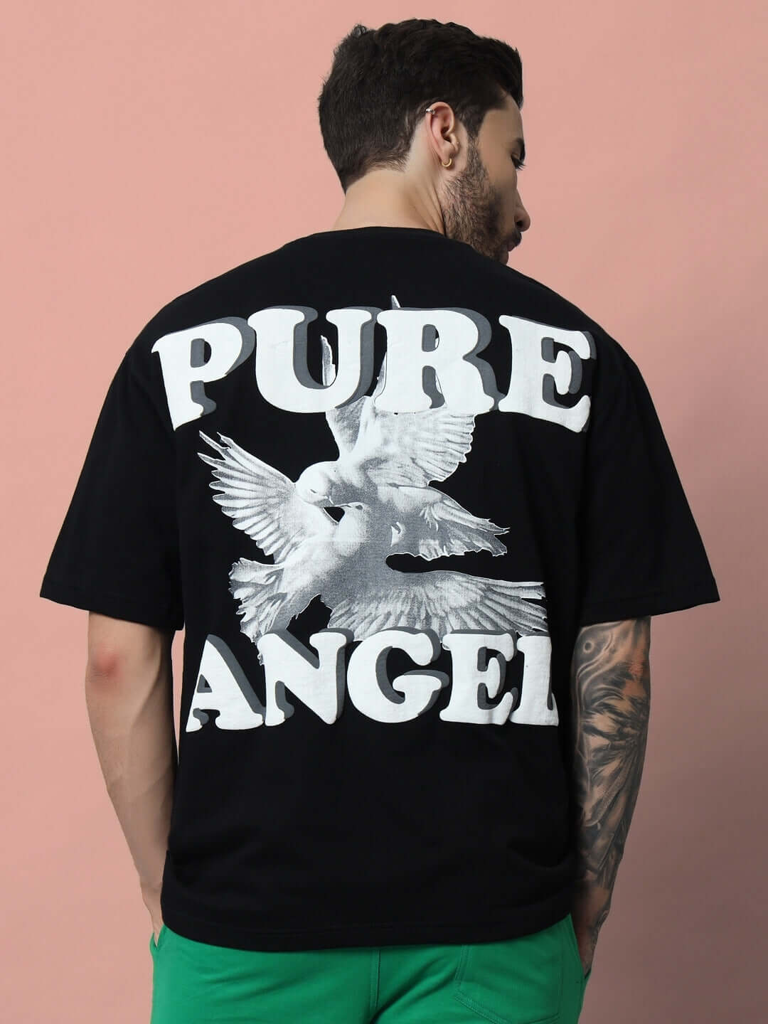 Man wearing Pure Angel black oversized t-shirt with white puff print design.