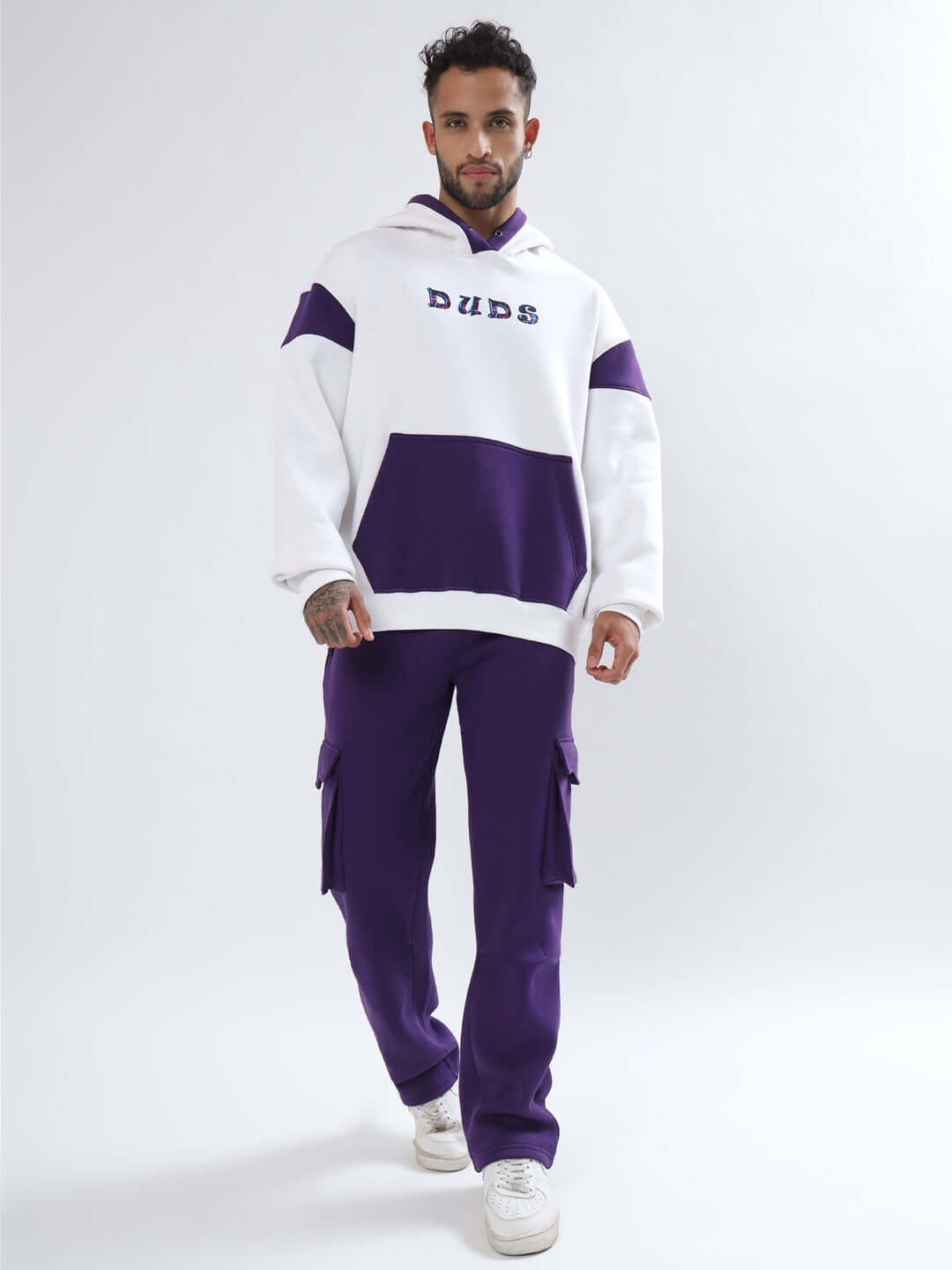 Man wearing 5 POCKET FLEECE SOLID CARGO PANT PURPLE paired with a matching hoodie, showcasing stylish casualwear with multiple pockets.