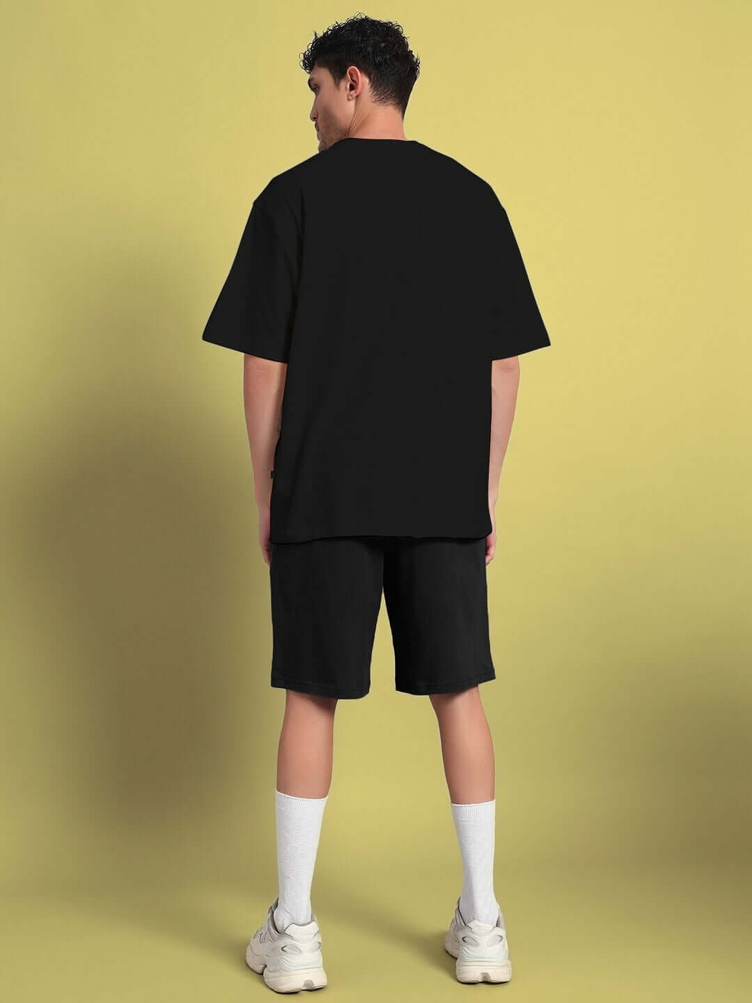 Back view of model in QUACK OFF COTTON CO-ORD SET BLACK, casual streetwear style, featuring black top and shorts.