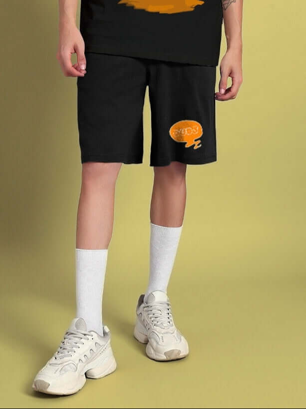 Person wearing QUACK OFF SUMMER COTTON SHORTS BLACK with "Quack Off" graphic, white shoes, and socks.