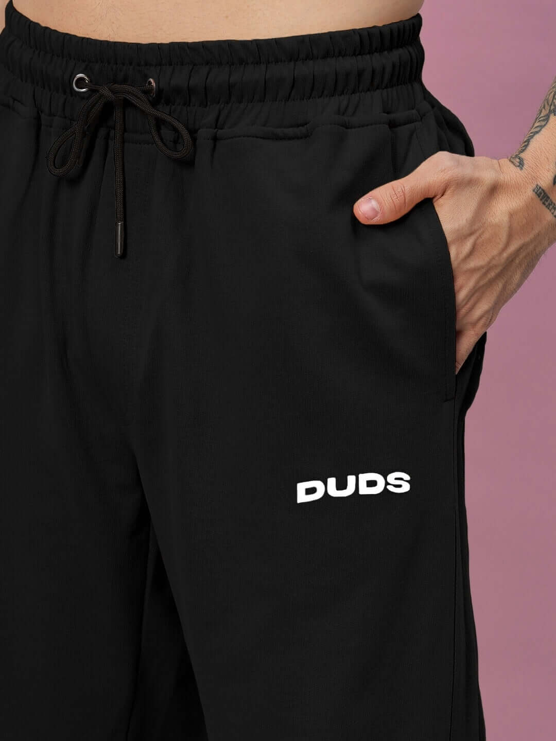 Close-up of black Quantum Relaxed-Fit Joggers with drawstring waist and DUDS logo, highlighting comfortable custom fit option.