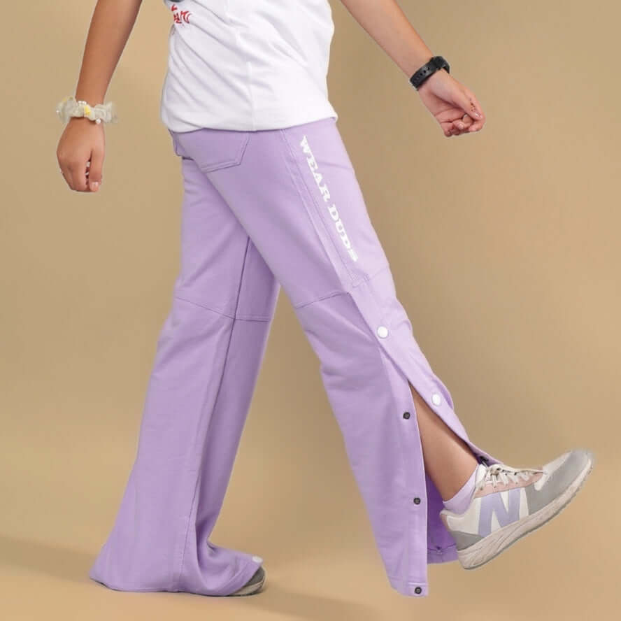 Child wearing lavender RACER JOGGER FOR BOYS & GIRLS with side buttons and sneakers.