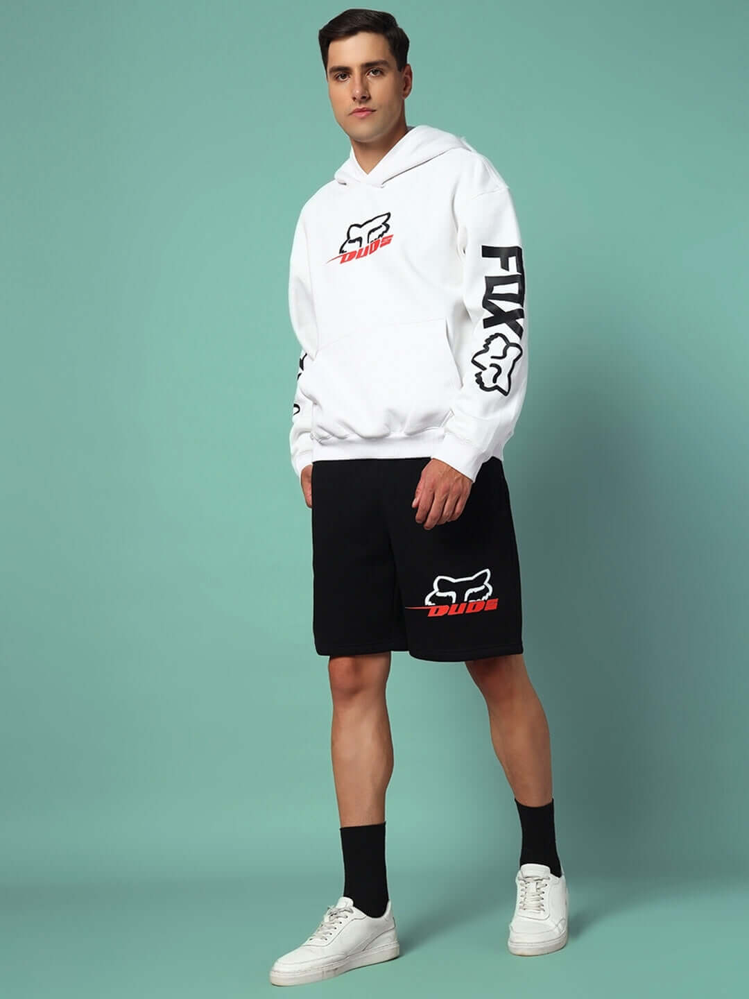 Man wearing Racing Fox Co-Ord in white and black by DUDS. Hoodie with logo on sleeve, matching shorts, stylish and trendy for casual wear.