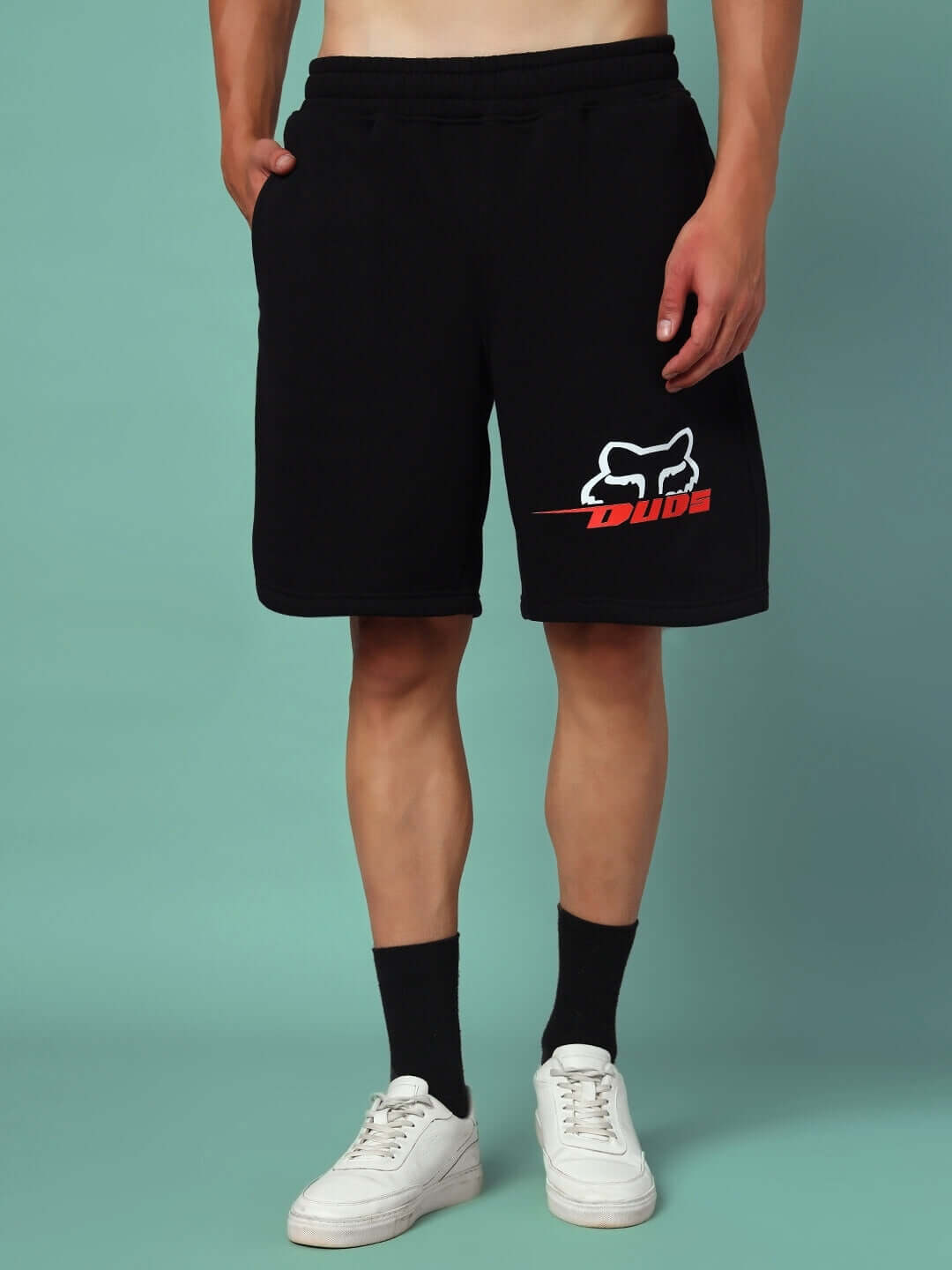 Person wearing RACING FOX FLEECE SHORTS BLACK with racing graphic, showcasing casual styled streetwear.