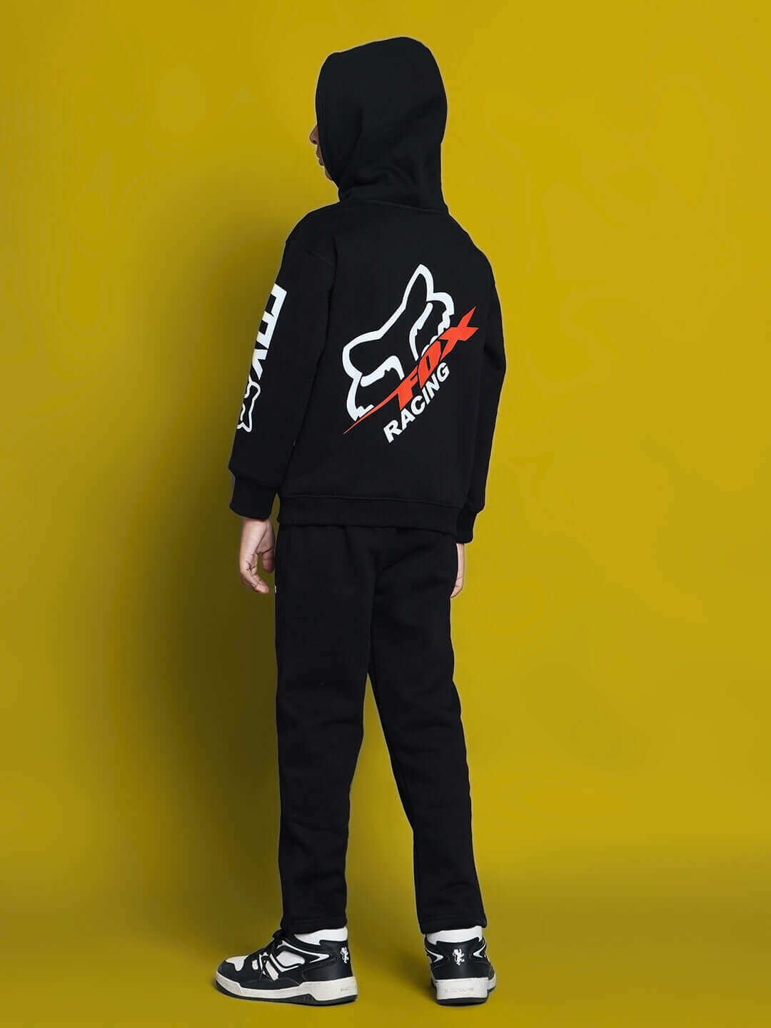 Child wearing RACING FOX FLEECE CO-ORD FOR BOYS GIRLS BLACK, featuring a racing-themed hoodie and joggers on a yellow background.