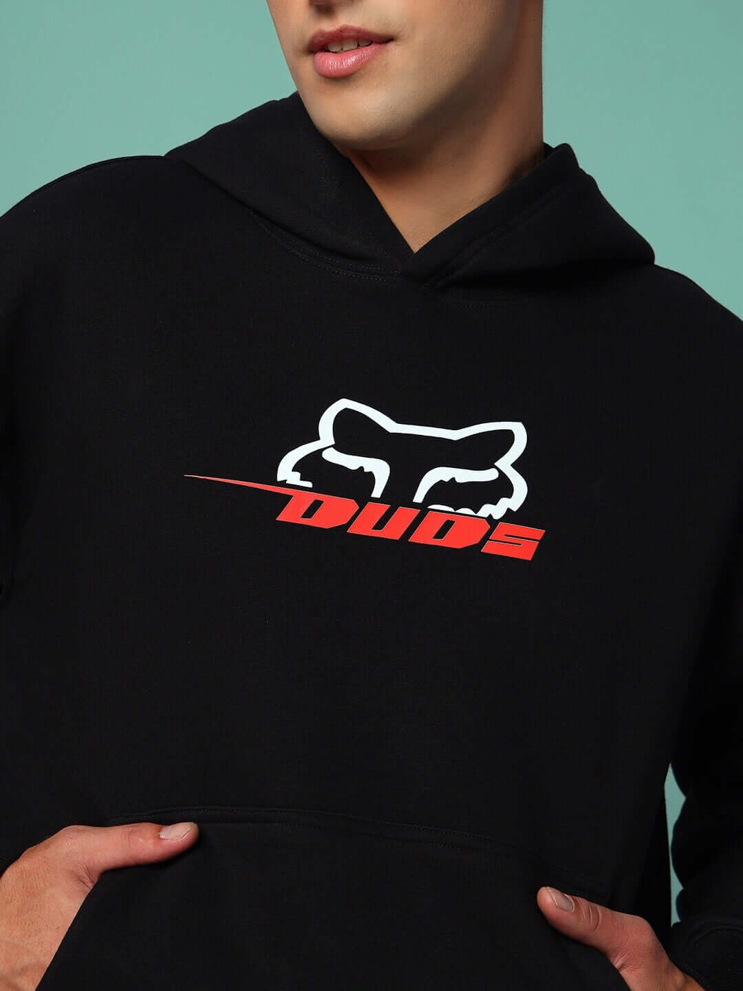 Man wearing RACING FOX COTTON FLEECE HOODIE BLACK with bold design, showcasing streetwear style and comfort.
