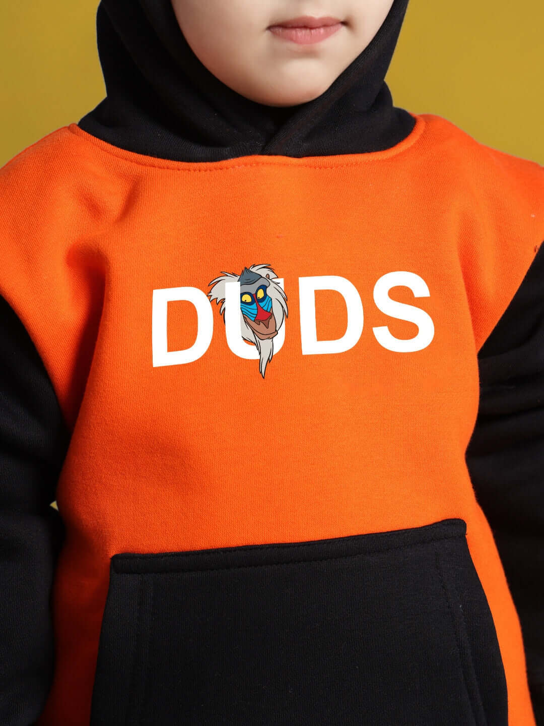 Child wearing DUDS orange-black Rafiki hoodie demonstrating front design.