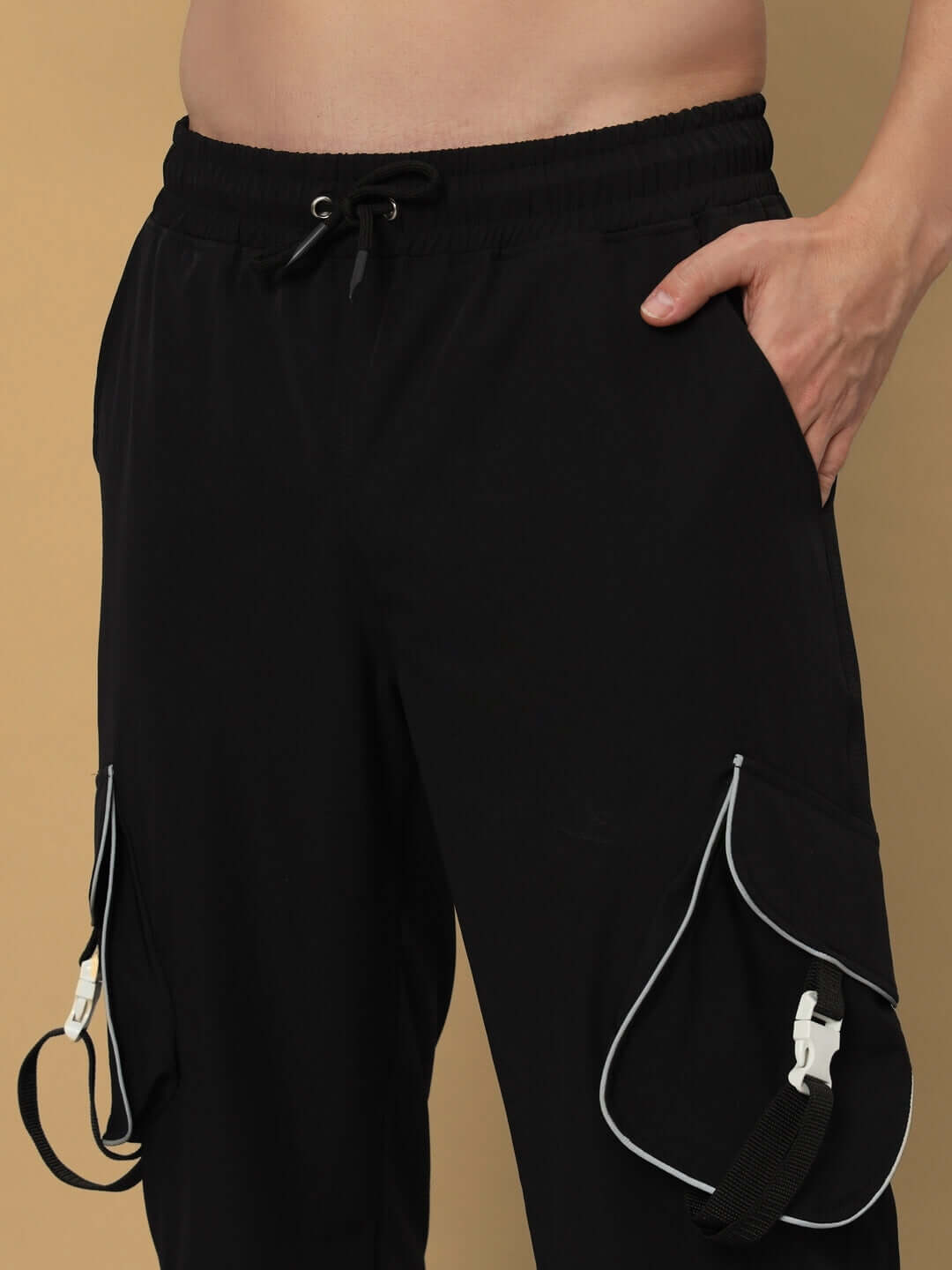 RAGGA Reflector Parachute Cargo Pants in Black with adjustable drawstring, showcasing practical side pockets and reflective details.