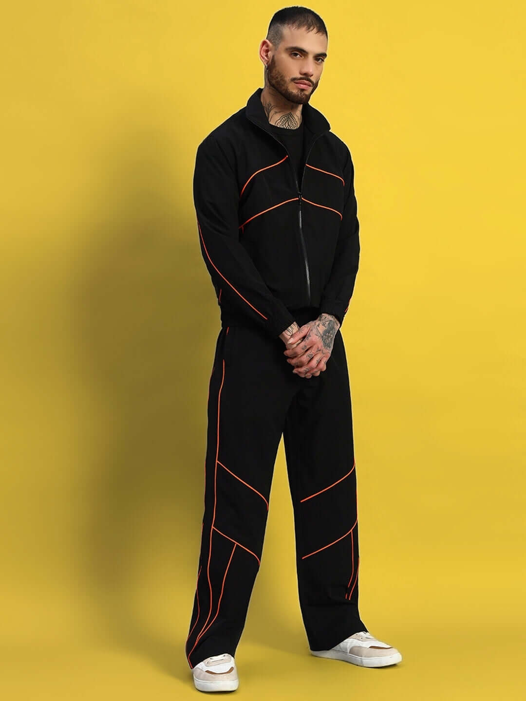 Model wearing RAIDER CO-ORD SET BLACK WITH ORANGE ACCENTS made from polyester fabric.