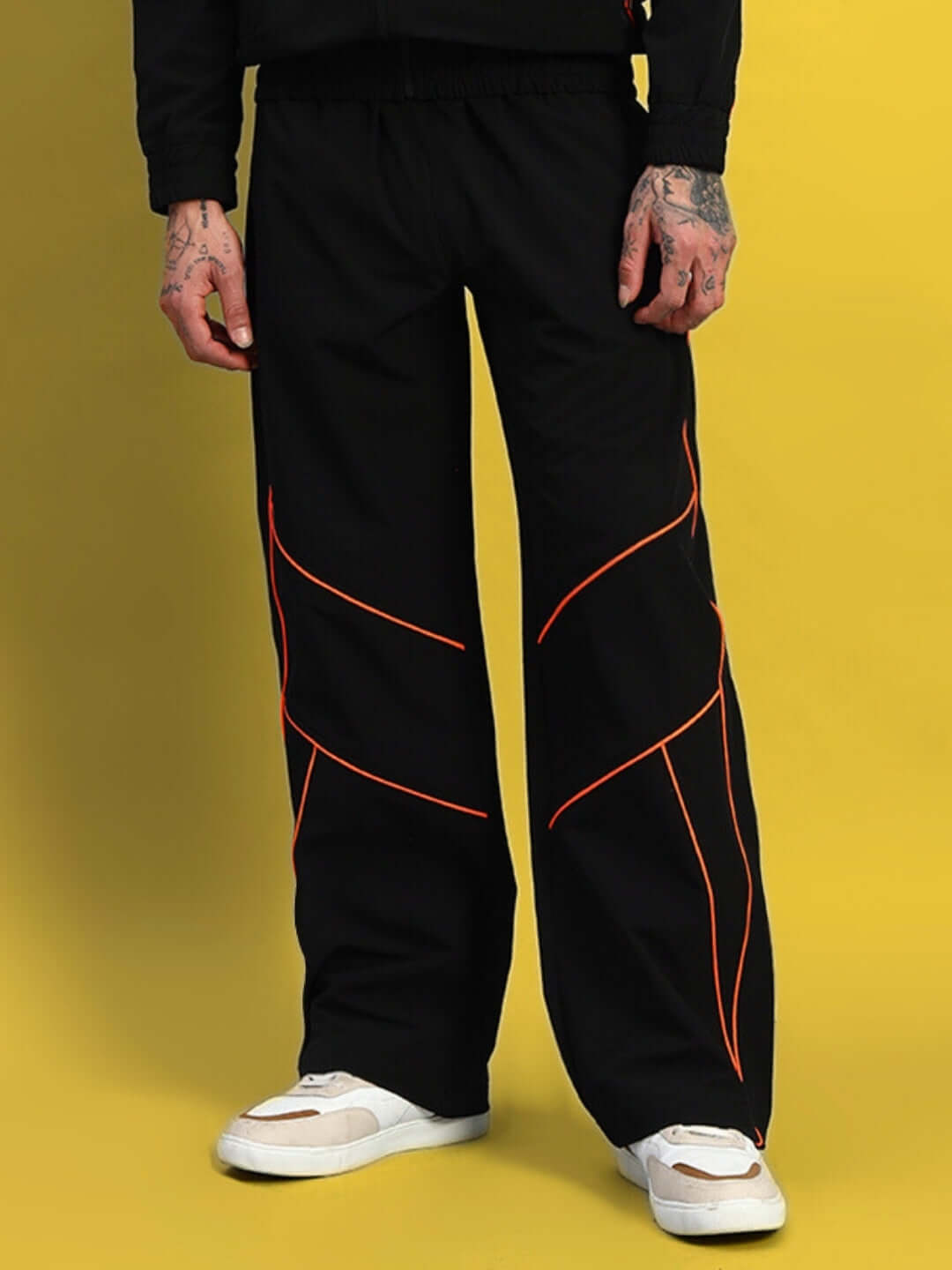 Black Raider Relaxed Pant Jogger by DUDS with red accents, tailored for comfort and style, shown on a yellow background.