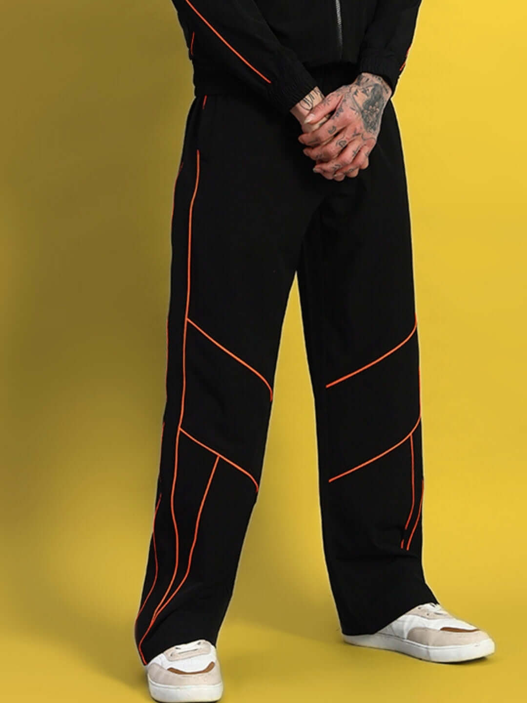 RAIDER RELAXED PANT JOGGER in black with orange trim, model wearing sneakers, showcasing the made-to-order comfortable fit by DUDS.