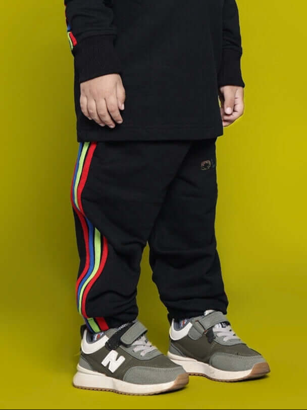 Child wearing black Rainbow Jogger with colorful stripes for boys and girls, made to order by DUDS.