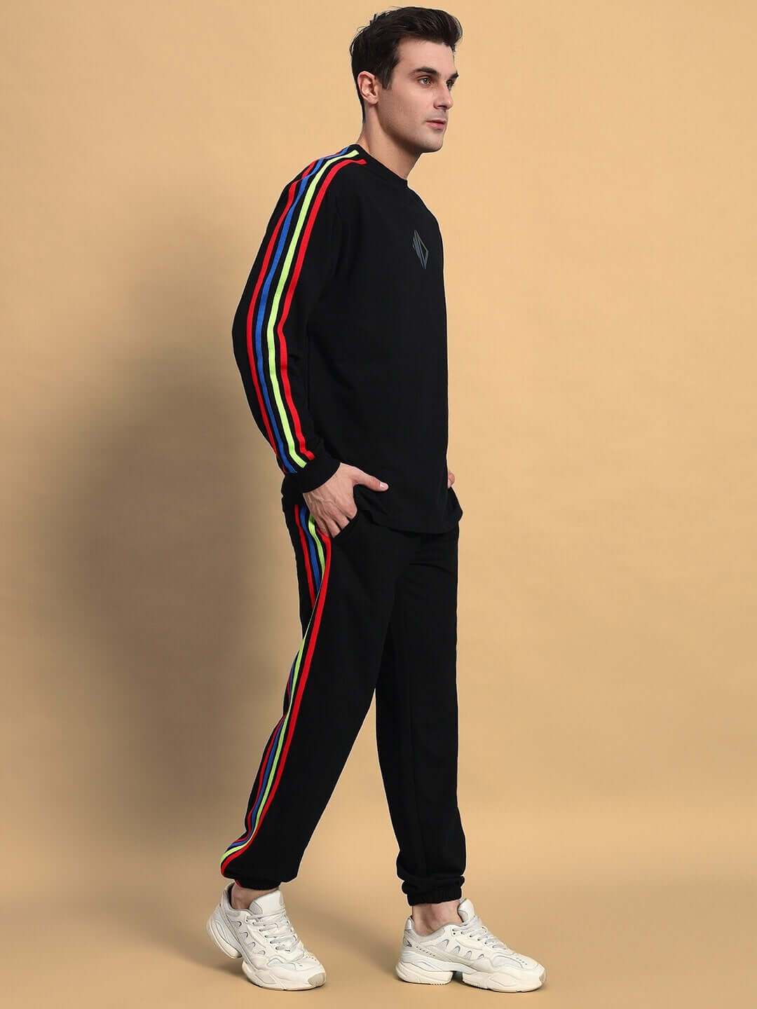 Model wearing RAINBOW OVERSIZED CO-ORD SET BLACK with rainbow stripe detail, relaxed fit joggers, and elasticated waistband, side view.